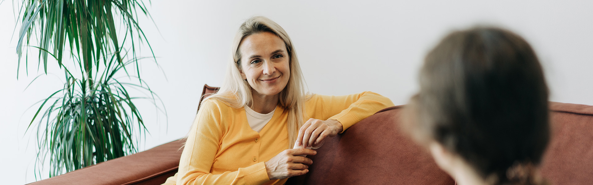 Woman sitting relaxed on her sofa while talking to a professional