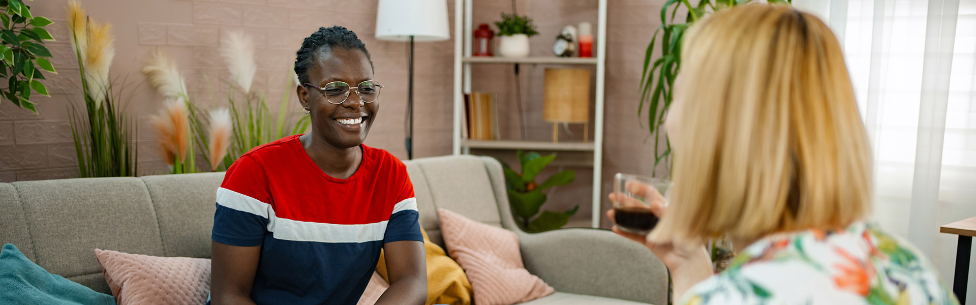 Woman and social worker sit on sofa in her living room