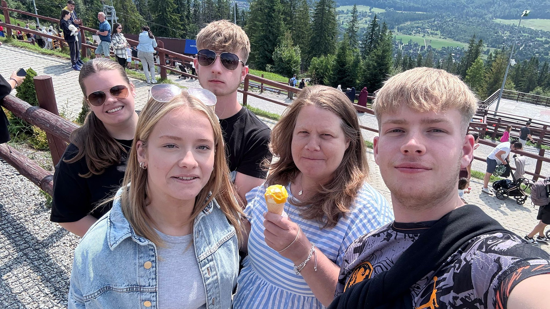 Lincolnshire Fostering Service foster carer, Jacqueline C. and family pose on a mountain as they take a selfie together.