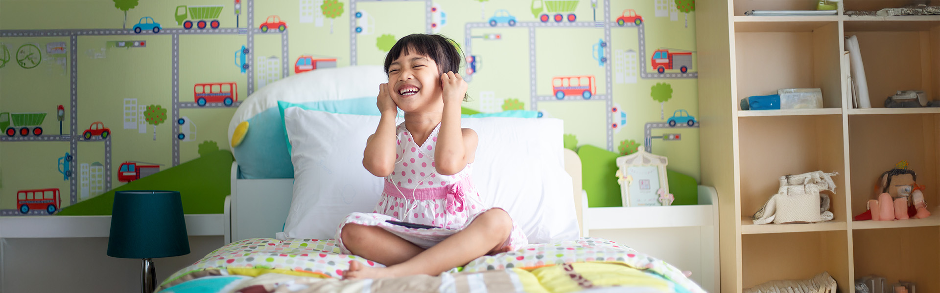 Child relaxing in bedroom using headphones to listen to music