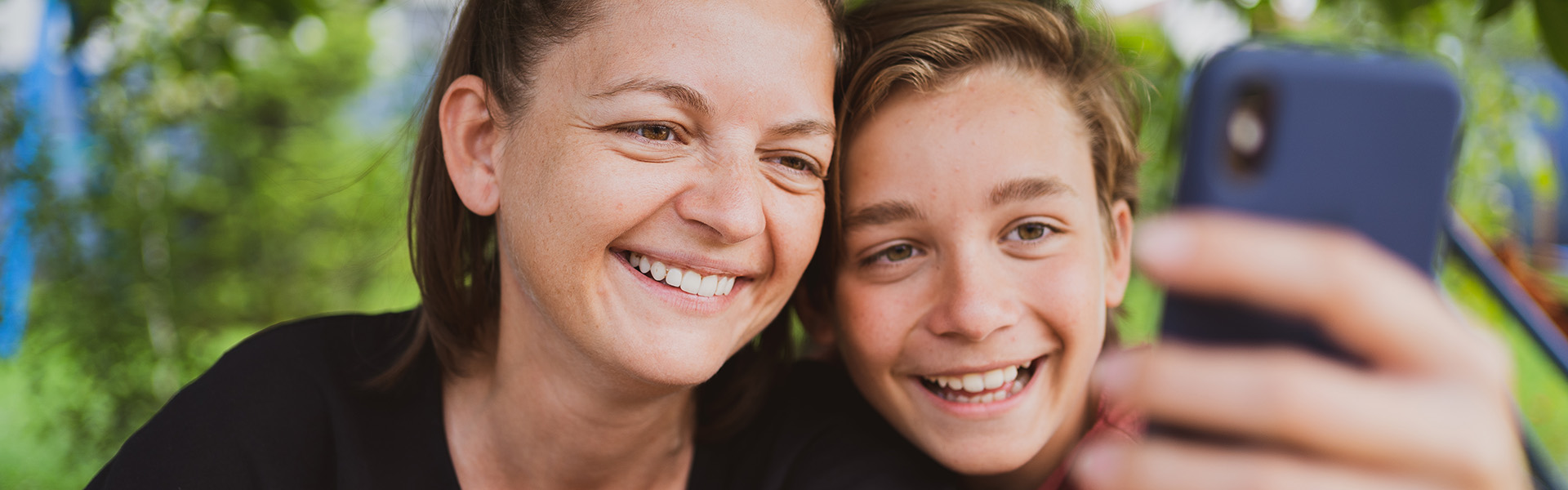 Young mother and son looking at phone screen